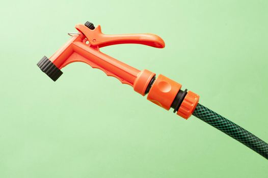Orange plastic garden spray nozzle on the end of a hosepipe for watering delicate seedlings and seed beds