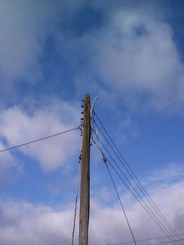 Low angle view looking up at a wooden telephone pole