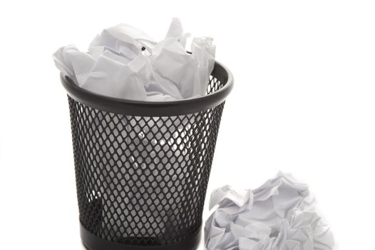 Mini wastepaper basket full to overflowing with crumpled white paper