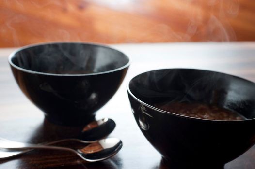 Two bowls of steaming hot onion soup for a tasty starter to a winter meal on a cold day