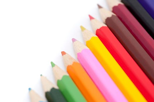 Artistic palette of coloured pencils in the colours of the rainbow arranged in a diagonal line with copyspace