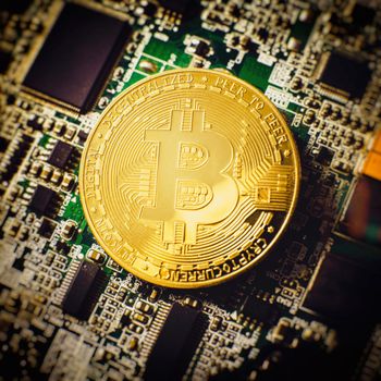 Blockchain technology bitcoin mining concept. Bitcoin golden coin on computer circuit board. banner copy space