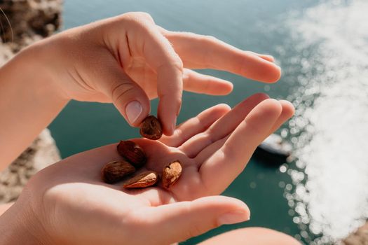 Unrecognizable caucasian woman eating young milky almond nuts. Healthy vegan food