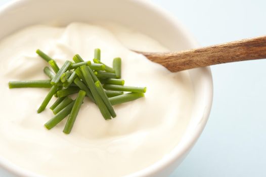Small bowl of thick and creamy soup with wooden spoon and topped with chopped herbs
