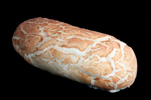 Uncut freshly baked white bread loaf with a crisp golden crust on a dark background