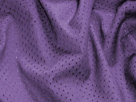 Soft luxurious folded purple fabric with a sateen pattern of darker dots in a full frame decor background