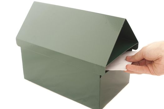 Postman delivering mail placing a letter into a metal letterbox, closeup of his hand isolated on white