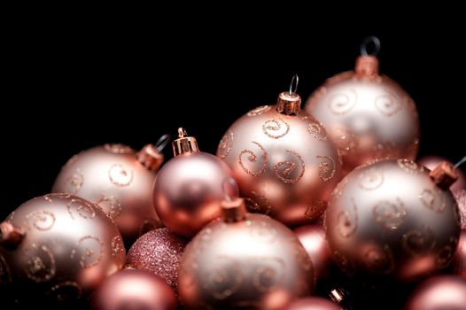 Collection of festive golden Christmas baubles against a black background with copy space