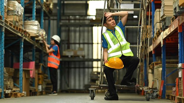 Storehouse employees workers in hardhats and and vests working together in warehouse. Logistics, and manufacture storehouse occupation concept.