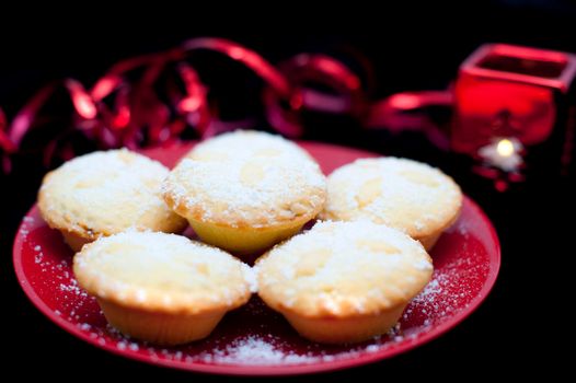 Plate of five golden freshly baked Christmas mince pies with a rich fruit filling sprinkled with sugar for a festive seasonal treat