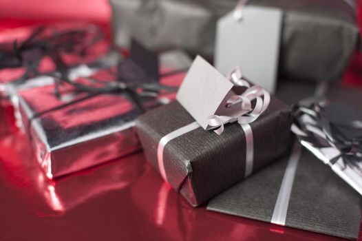 an assortment of small christmas presents on a red foil background