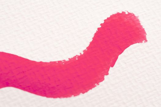 Crimson paint brushstroke on canvas or textured watercolor paper conceptual of art and creativity