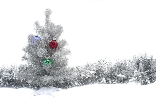 a silver colored artifical chritmas tree and a line of silver tinsel