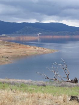 rain clouds form over a half empty reservoir bringing a welcome top-up to the water supply