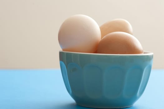 Bowl of fresh brown and white farm eggs ready for making breakfast or baking with copy space
