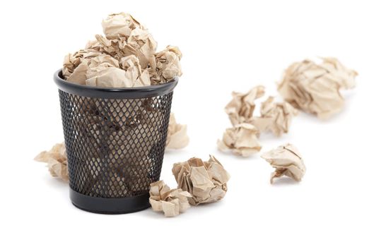 Discarding paper rubbish into a dedicated bin for recycling which is overflowing onto the floor