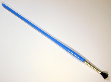 Single blue paintbrush with medium size tip on gray background with shadow