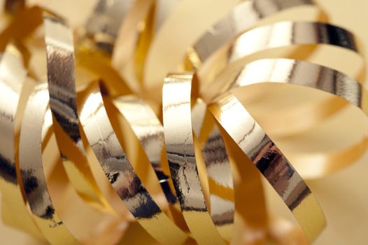 Close Up Still Life of Shiny Gold Ribbon Curl, Macro Shot of Decorative Metallic Wrapping Supplies