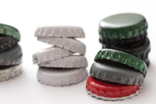 a stack of beer bottle tops on white background
