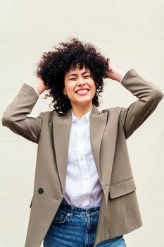 stylish business woman smiles happy shaking her curly hair, concept of success and youth