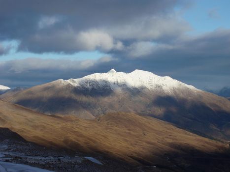 a snow covered new zealand mountain, as viewed from coronet peak