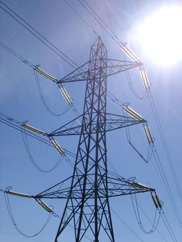 Steel lattice high voltage electricity pylon distributing electrical energy through the grid