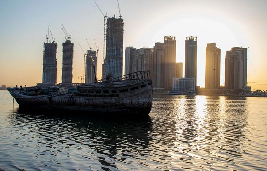 Sunrise in Jadaf area of Dubai, view of Dubai creek Harbor construction of which is partially completed. Old abandoned ships can be seen on the scene. Outdoors