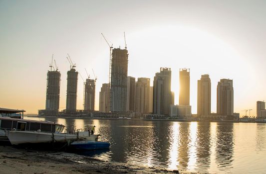 Sunrise in Jadaf area of Dubai, view of Dubai creek Harbor construction of which is partially completed. Old abandoned ships can be seen on the scene.Outdoors