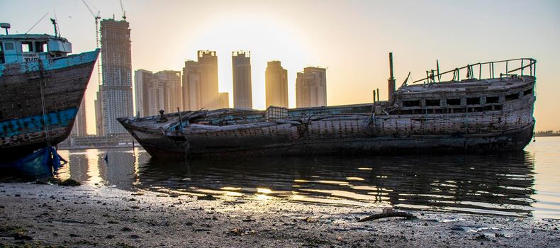 Sunrise in Jadaf area of Dubai, view of Dubai creek Harbor construction of which is partially completed. Old abandoned ships can be seen on the scene. Outdoors