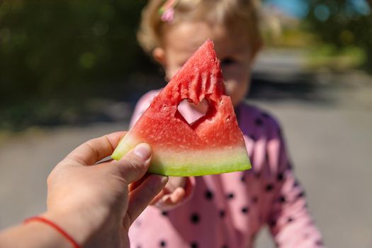 The child eats watermelon in summer. Selective focus. Kid.