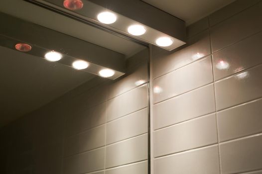 a row of halogen lights over a bathroom mirror