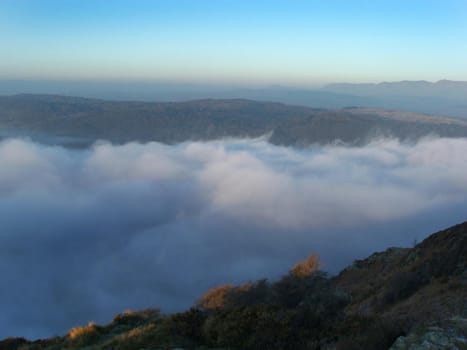 looking down onto a valley full of clouds / mist