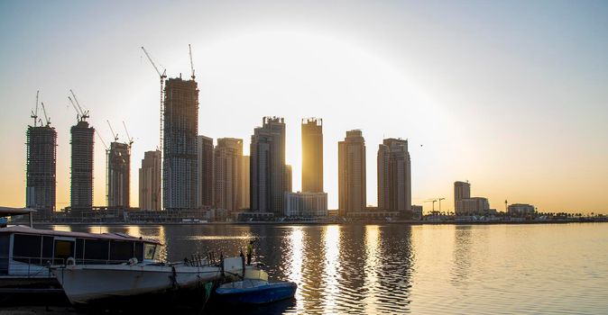 Sunrise in Jadaf area of Dubai, view of Dubai creek Harbor construction of which is partially completed. Old abandoned ships can be seen on the scene. Outdoors