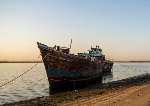 Sunrise in Jadaf area of Dubai. Old,wooden, abandoned ships can be seen on the scene. Outdoors