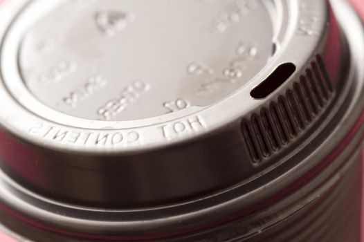 Detail of the lid of a plastic takeaway coffee cup viewed at an angle to enhance the text - hot contents - on the rim