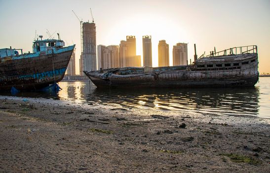 Sunrise in Jadaf area of Dubai, view of Dubai creek Harbor construction of which is partially completed. Old abandoned ships can be seen on the scene. Outdoors