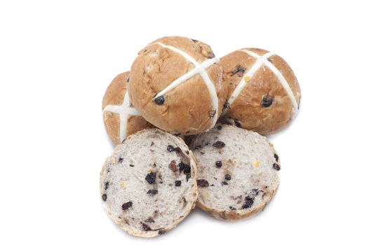 Fresh baked delicious fruity Easter Hot Cross Buns with one slice open to show the raisins and the others arranged to show the cross symbolic of the Crucifixion, on white with copy space