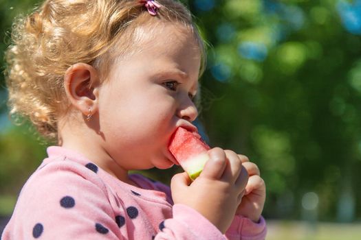 The child eats watermelon in summer. Selective focus. Kid.