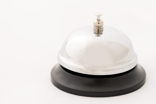 Close up of a silver metal hotel service bell isolated on a plain white background with copy space.