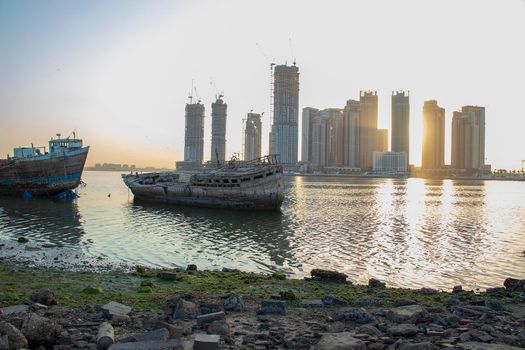 Sunrise in Jadaf area of Dubai, view of Dubai creek Harbor construction of which is partially completed. Old abandoned ships can be seen on the scene. Outdoors