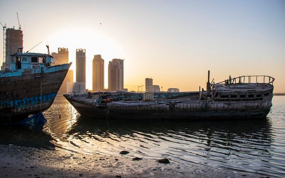 Sunrise in Jadaf area of Dubai, view of Dubai creek Harbor construction of which is partially completed. Old abandoned ships can be seen on the scene.