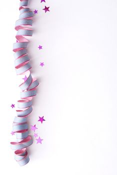 Colorful party sidebar with a coiled pink streamer and stars over a white background for your celebratory wishes or invitation