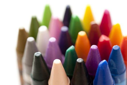 Bundle of colorful wax crayons with a close up shallow DOF view of the points over white in an educational and creativity concept