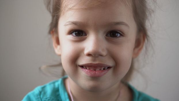 Portrait Funny Happy little kid close up happy preschool girl smiling child looking at camera pretty natural face. sincere emotions ashamed, embarrassed clean skin dermatology, pediatric dentistry.