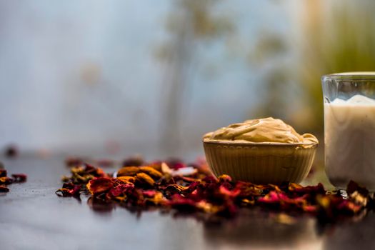 Multani mitti or fuller's earth or mulpani mitti face mask on wooden surface in glass bowl consisting of milk, almonds, and bentonite clay.For the treatment of softer skin.