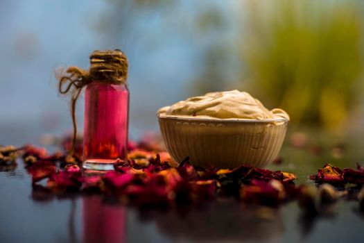 Ubtan/face mask/face pack of Multani mitti or fuller's earth on wooden surface in a glass bowl consisting of Multani mitti and rose water for the remedy or treatment of oily skin.On wooden surface.;