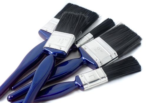 Set of new paint brushes for DIY and interior decorating and painting lying in a heap on a white background