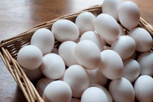 Wicker basket filled with farm fresh white chicken eggs at a market for a healthy cooking ingredient and breakfast