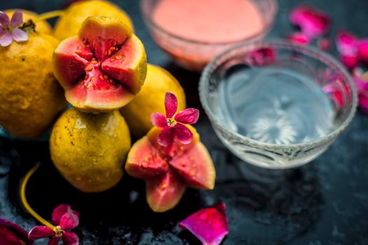 Guava face mask for glowing skin on a wooden surface with a blurred background consisting of some guava pulp well mixed with water.