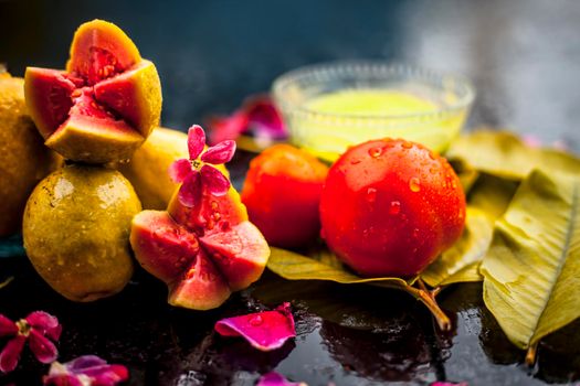 Best cheap face mask for tanned skin on wooden surface un a glass bowl consisting of guava leaves paste well mixed with some tomato pulp. Shot with entire ingredients with fantastic colors.